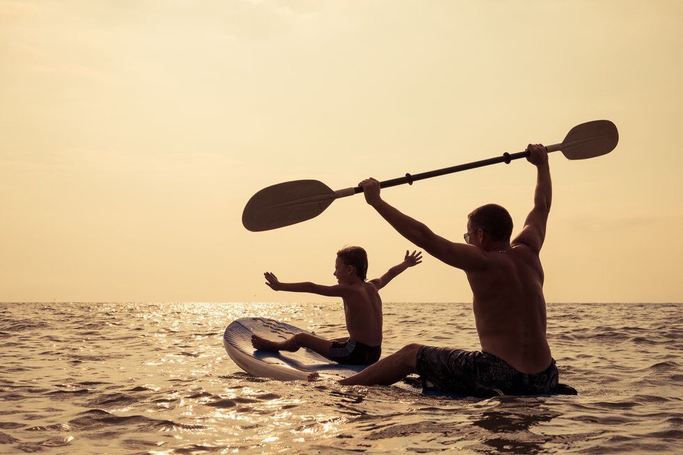 father and sun paddle boarding